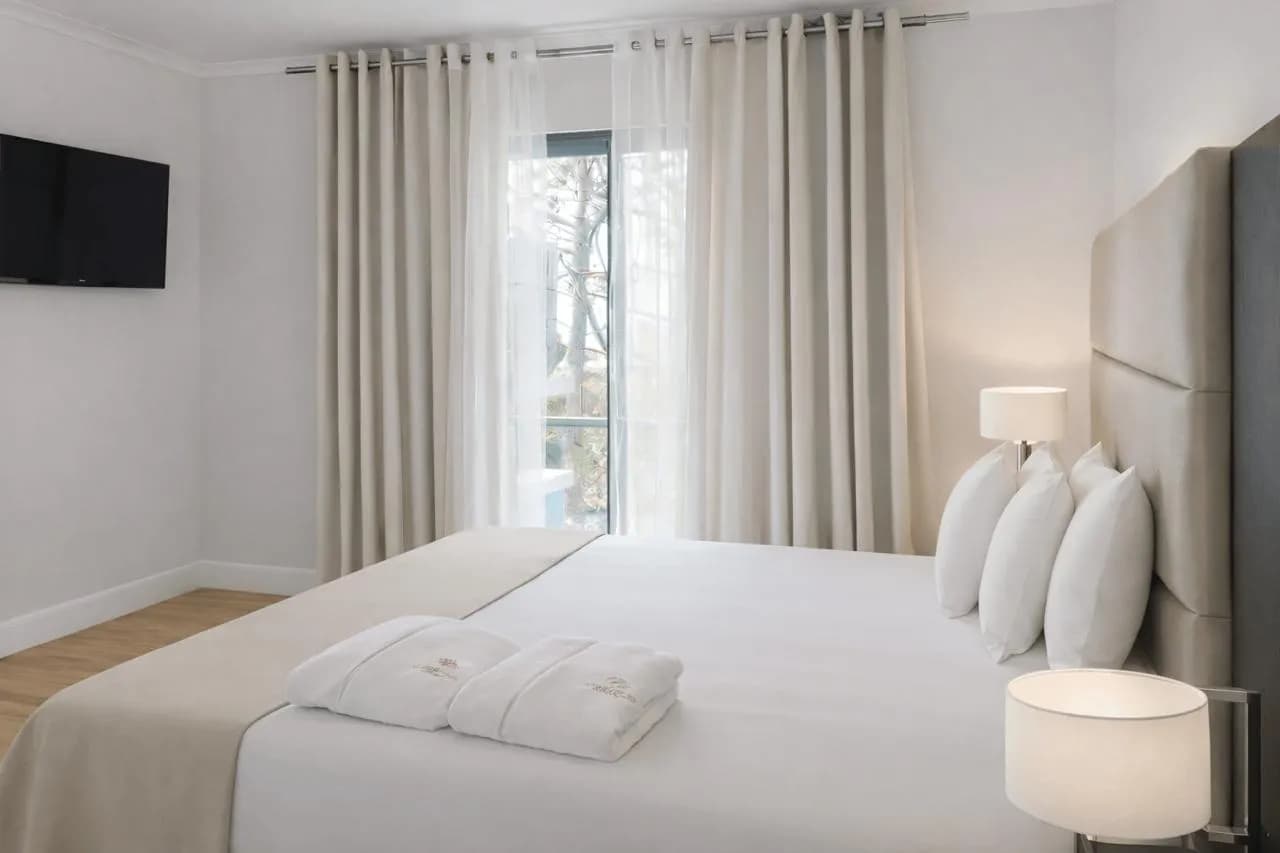 Bright en-suite bedroom with luxury white linens at Atlantic Heritage, premium Azores accommodation